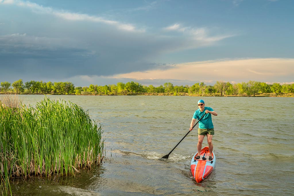 travel man paddle boarding in water